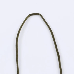Détail de la bretelle tressée verte sur robe en velours avec vue macro de la texture