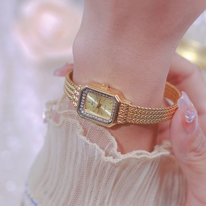 Elegant gold square watch for women with rhinestone bezel on a model's wrist