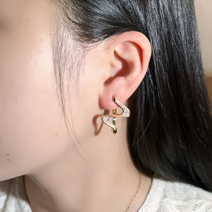 Elegant 24k gold plated wave-shaped earrings with micro-paved zircons on female model