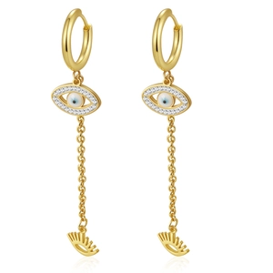 Detailed macro of gold tassel earrings with evil eye pendant and crystal accents