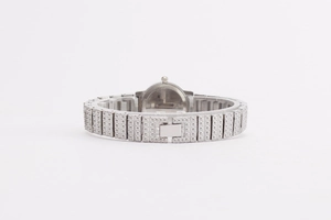 Detail view of silver lady watch with textured metal chain strap and smooth case back