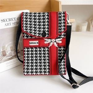 Detail of red and black knit crossbody bag featuring houndstooth pattern and Grace label