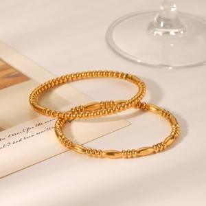 Elegant 18K gold-plated stainless steel bead bracelets displayed on a warm white background