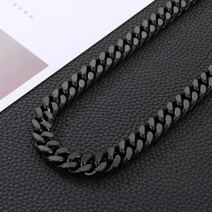 Close-up of matte black stainless steel Cuban chain necklace on leather texture