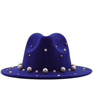 Nahaufnahme des royalblauen Wollhutes mit eleganten weißen Perlen und goldenen Akzenten