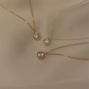 Detailed close-up of zircon necklaces in gold, silver, and rose gold on satin