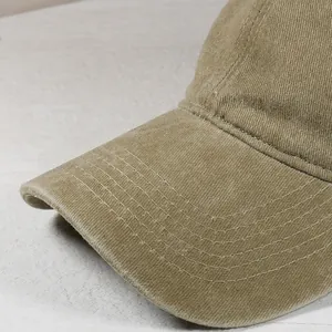 Dettaglio del cappello da baseball in velluto a coste kaki con cuciture precise