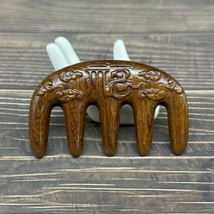 Detail of sandalwood massage comb with five teeth and embossed auspicious clouds patterns