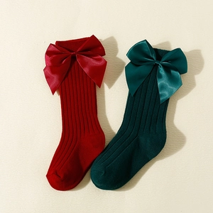 Spanish style Christmas baby socks with large satin bows in red and forest green