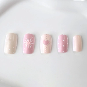 Set di unghie finte rosa con cuori, fiori e pois, design elegante e minimalista