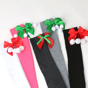 Detail of Christmas over-knee socks with satin bows and plush pom-poms in five colors