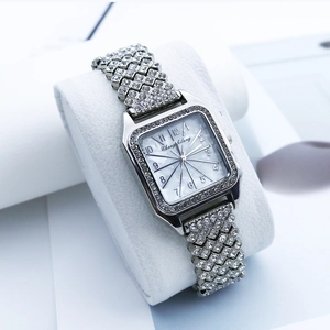 Montre à quartz carrée pour femme avec strass et bracelet en métal argenté sur un coussin blanc
