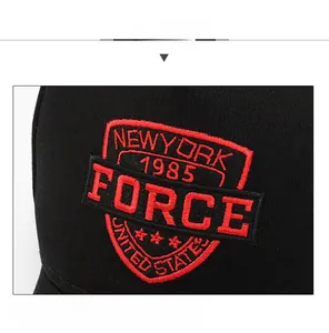 Detailed close-up of red and black 3D embroidery on a black cotton baseball cap
