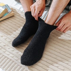Close-up of thick black coral fleece socks showing soft plush texture and comfort fit
