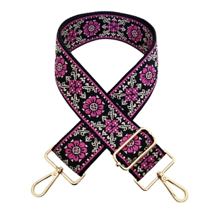 Close-up of ethnic style embroidered floral bag strap with golden metal swivel hooks