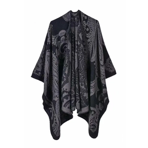 Detailed view of gray paisley pattern on a soft wool blend shawl hung on a hanger