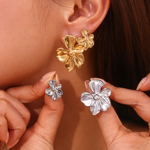Detailed close-up of 18K gold plated crescent flower petal stud earrings on model