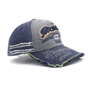 Detail of distressed denim baseball cap with vintage Rock embroidery and frayed edges