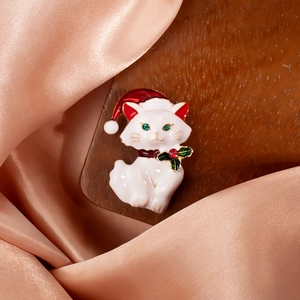 Cute white Christmas cat brooch with red hat on elegant champagne silk background