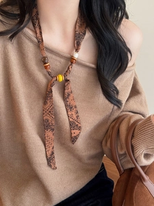 Detail view of Bohemian paisley chiffon fabric necklace with wooden beads on model