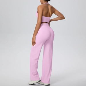 Detail of pink halter neck sports vest and wide leg yoga pants set on a standing model