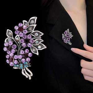 Elegant crystal flower brooch with purple rhinestones on a dark suit blazer