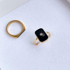 Detail view of gold rings featuring black enamel inlay and centered cubic zirconia accents