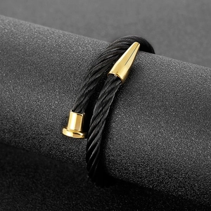 Fashionable twisted black steel cable nail bracelet with polished gold-tone metal accents