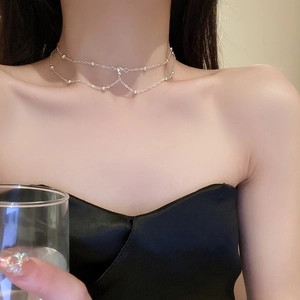 Detail of silver double layer chain choker with minimalist beads and crystal on neck