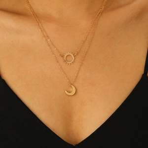 Close-up of double-layer gold sun and moon pendants necklace on a female model
