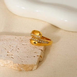 Detailed macro of a gold crossover ring with pave diamonds on a stone pedestal