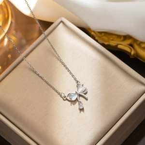 Silver bow necklace with cat-eye stone pendant displayed in a premium jewelry gift box