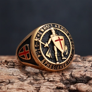 Macro shot of gold saint shield ring with engraved Bible verse on rough bark texture