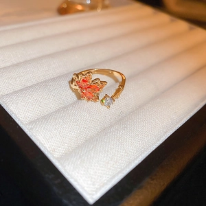 Detail of gold-plated dragon ring with orange maple leaf design and zircon stone