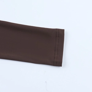 Détail des poignets élastiques et double couture sur la robe marron à manches longues