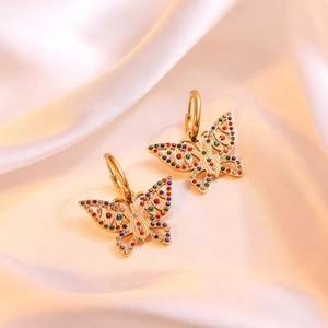 Detail of 18K gold butterfly earrings with colorful zircons on luxury silk fabric