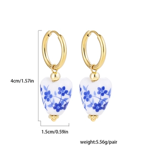 Detail of blue and white porcelain heart earrings with size measurements in centimeters