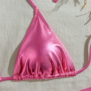 Close-up of metallic pink triangle bikini top with shimmering foil finish and drawstring detail