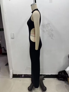 Detalle del recorte en la cintura y el cuello alto de un vestido negro entallado sin mangas