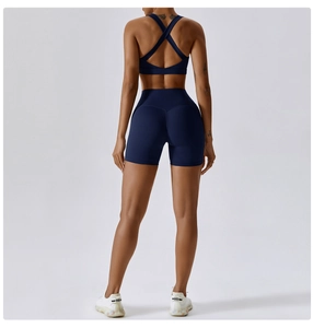 Dettaglio del reggiseno sportivo incrociato e pantaloncini fitness a vita alta blu