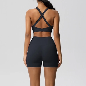 Close-up of black yoga set featuring a criss-cross back sports bra and high-waisted shorts