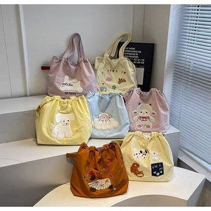 Collection of colorful canvas tote bags with cartoon animal patches under natural light
