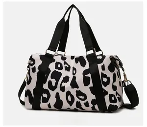 Detail of cow print travel bag with golden metal hooks and black nylon straps
