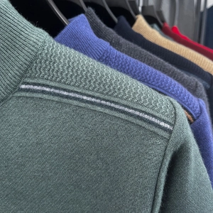 Detail of knit sweater shoulder showing herringbone stitch and contrast stripes