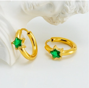 Detail of gold circular earrings with green star-shaped cubic zirconia and elegant finish