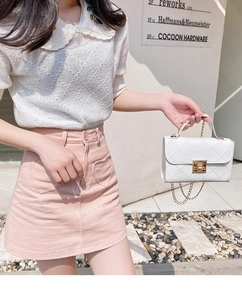 Close-up of a white quilted chain crossbody bag paired with a pink heart pocket skirt