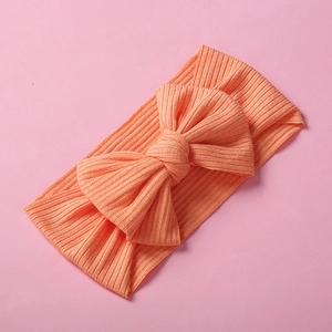 Fascia per neonati in maglia a costine con grande fiocco arancione caldo, vista piatta