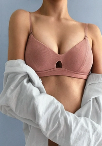Detail of dusty pink ribbed knit bralette fabric texture on female model with white shirt