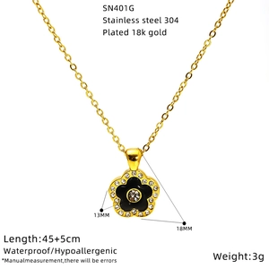 Detail of 18K gold plated heart pendant with black enamel and crystal inlay on a chain