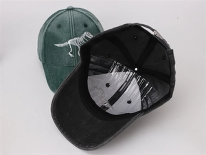 Detail of kids baseball cap showing dinosaur skeleton embroidery and internal structure